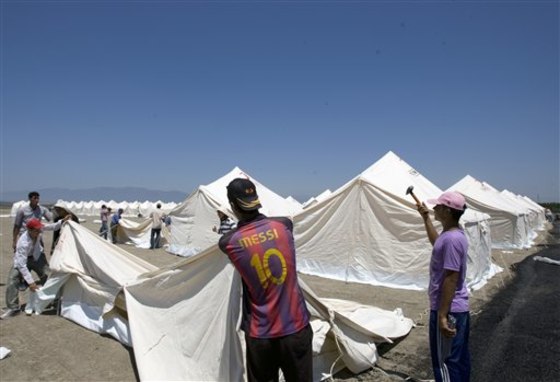 Turkish Red Crescent workers pitch tents Friday in a new camp that can receive up to 15,000 people for possible Syrian refugees in the Turkish town of Apaydin in Hatay province, Turkey.
